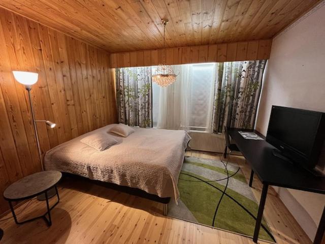 Schlafzimmer mit einem Bett und einem Flachbild-TV in der Unterkunft Huoneisto Tikkakoski - Apartment in Tikkakoski in Tikkakoski