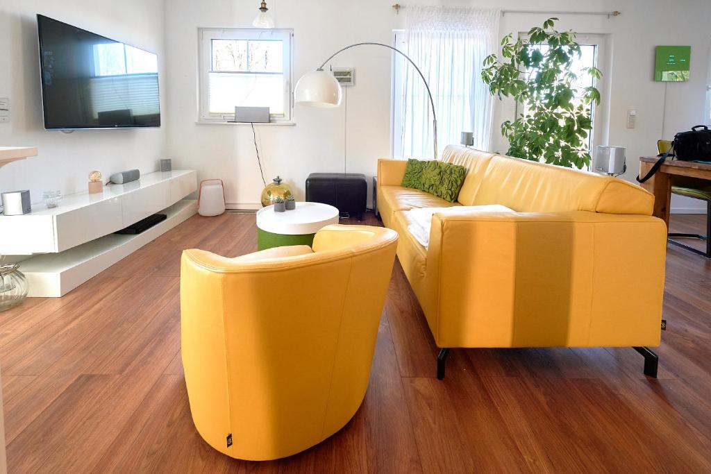 un soggiorno con 2 sedie gialle e un divano di SEEVILLA Kormoran a Göhren-Lebbin