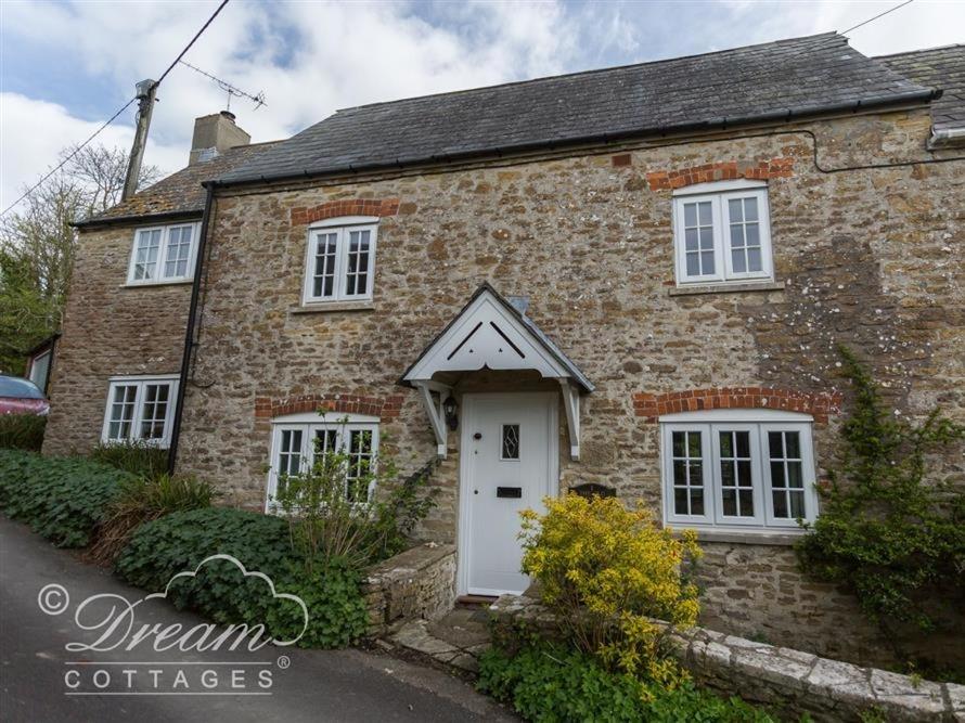 an old brick house with a white door at The Old Reading Room in Portesham