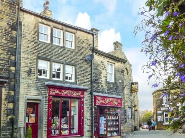 an old brick building with red trim on a street at Clock View in Haworth