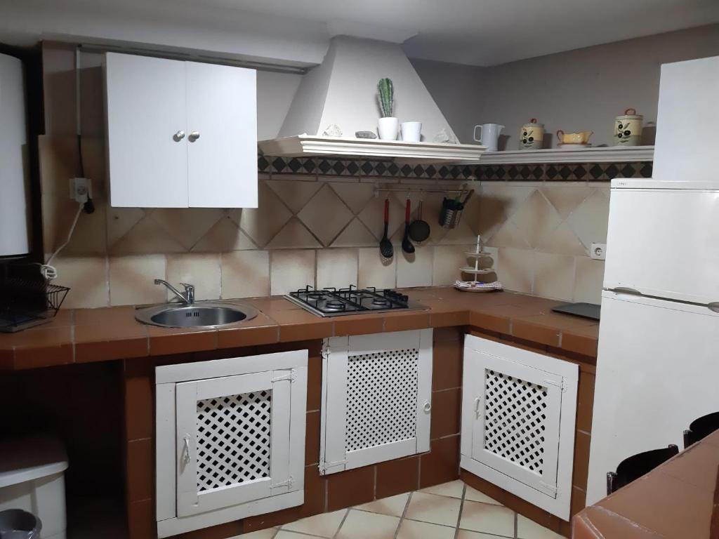 uma cozinha com armários brancos e um lavatório em Apartamento en sanxenxo duplex em Sanxenxo
