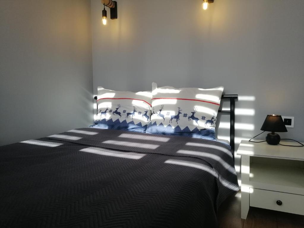 sypialnia z czarno-białym łóżkiem z lampką w obiekcie Apartament w Centrum w Szczecinie