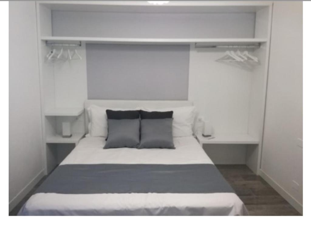 1 dormitorio blanco con 1 cama con 2 almohadas en Residenza Villa Cristalli, en Piacenza