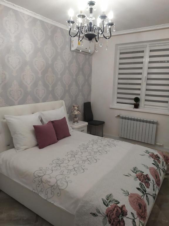 um quarto com uma cama grande e um lustre em HPC Luxury Apartaments em Tiraspol