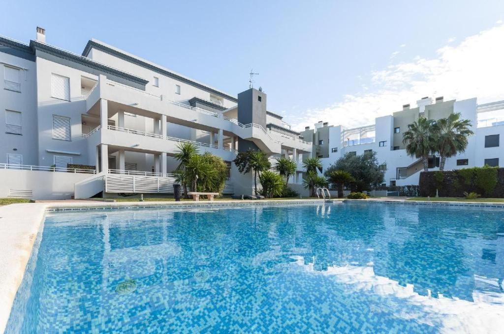 une grande piscine devant un immeuble dans l'établissement Oasis Hoyo 12 - Oliva Nova playa MET&GOLF, à Oliva