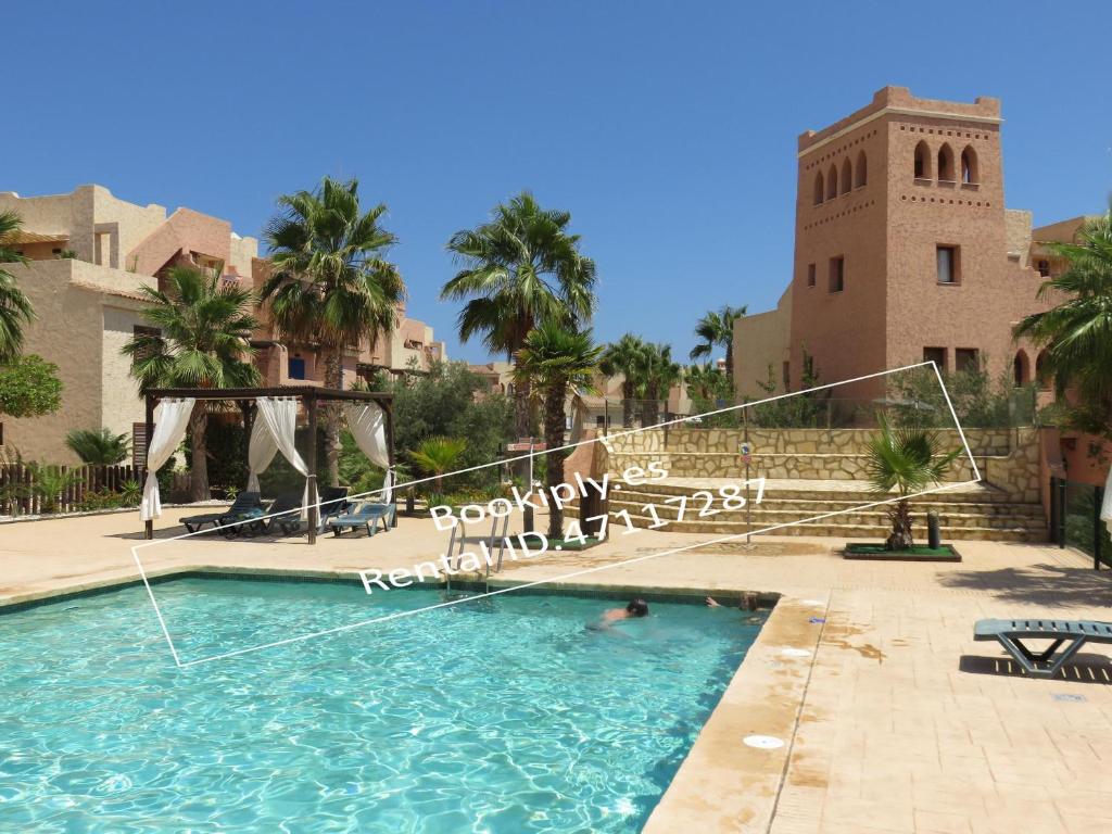a swimming pool in front of a building with a clock tower at Kasbah del Puerto Rey Precioso Bajó in Playas de Vera