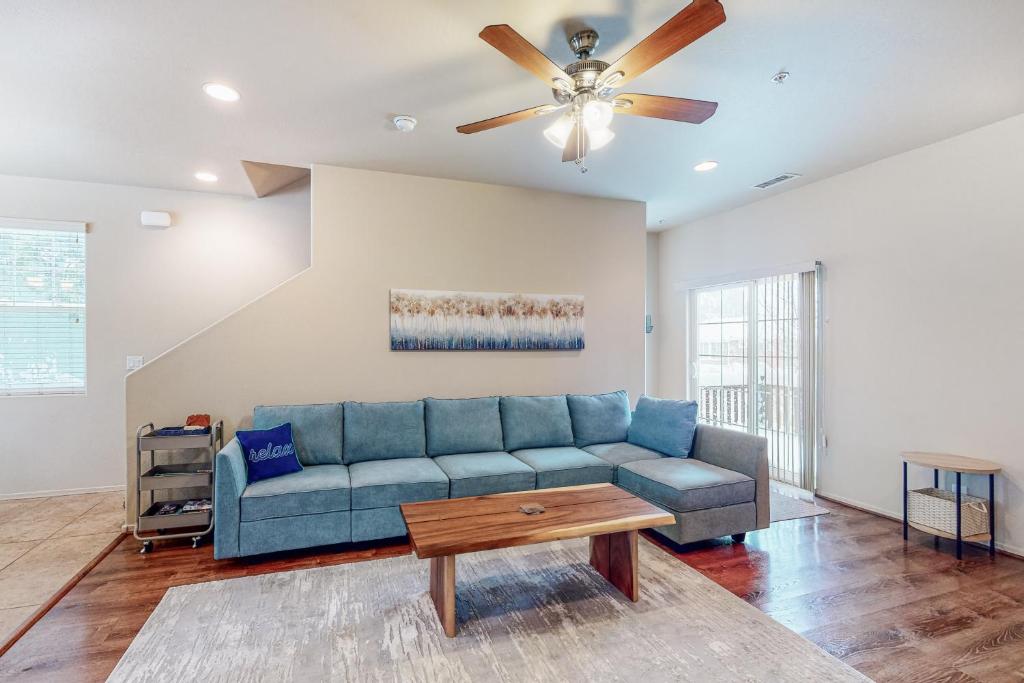 uma sala de estar com um sofá azul e uma ventoinha de tecto em Pikes Peak West em Flagstaff