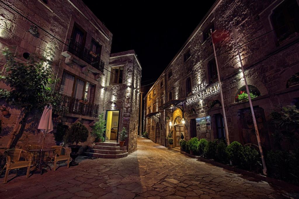 une rue vide la nuit avec un bâtiment dans l'établissement Assos Kervansaray Hotel - Special Category, à Assos