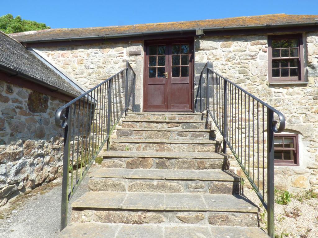 a set of stairs leading to a door of a stone building at The Granary in Saint Erth