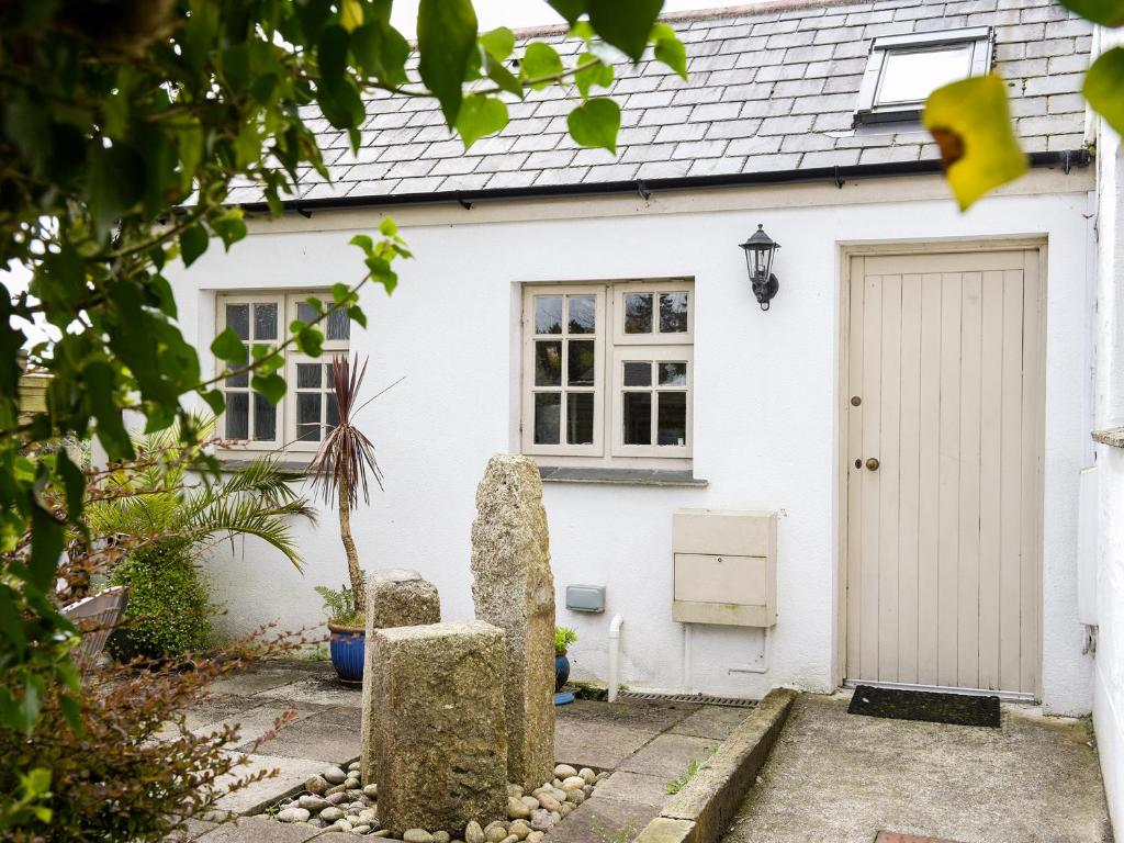 a white cottage with a gate and a door at Willow Cottage in Lostwithiel