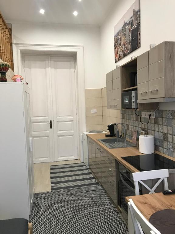 a kitchen with a white door and a refrigerator at Móra apartman 2 in Kiskunfélegyháza