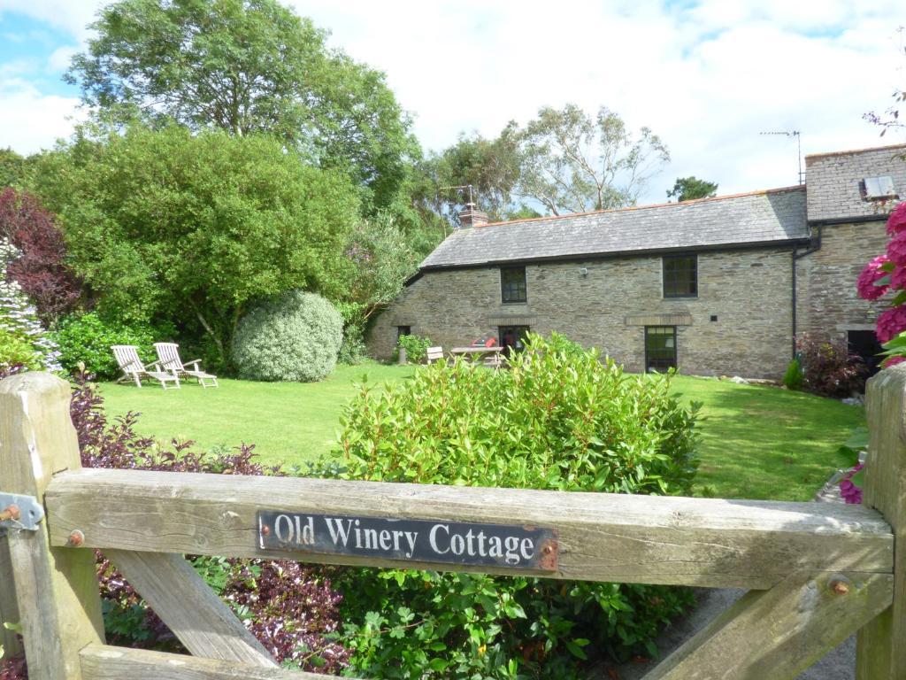 a wooden bench in front of an old wilkinson cottage at Old Winery Cottage in Golant