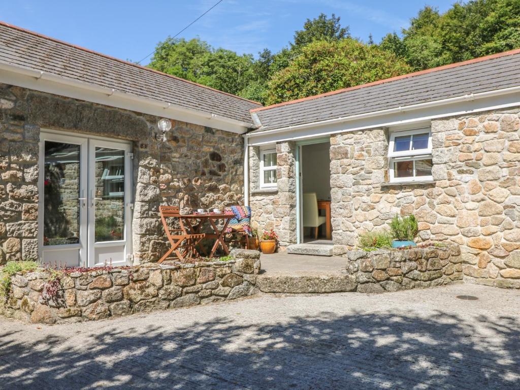 a stone house with a table in front of it at Pond Cottage in Truro