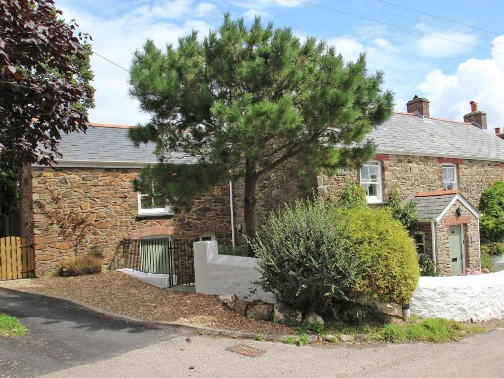 a brick house with a tree in front of it at Mithian Cottage in St. Agnes