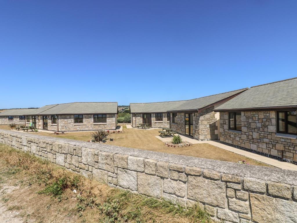 a stone retaining wall in front of a building at Surfside in Marazion