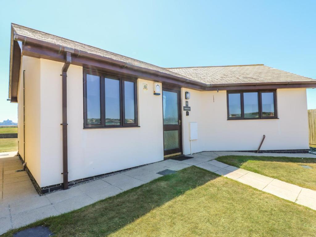 a house with white doors and a yard at Shoreline in Marazion