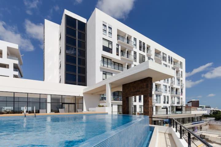 un edificio con piscina frente a un edificio en San Francisco by Andiani Travel en Cancún