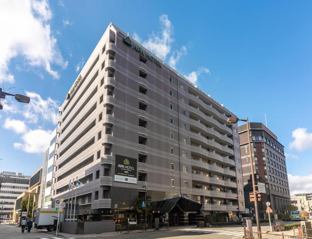 un grand bâtiment gris dans une rue de la ville dans l'établissement APA Hotel Kyoto Ekimae, à Kyoto