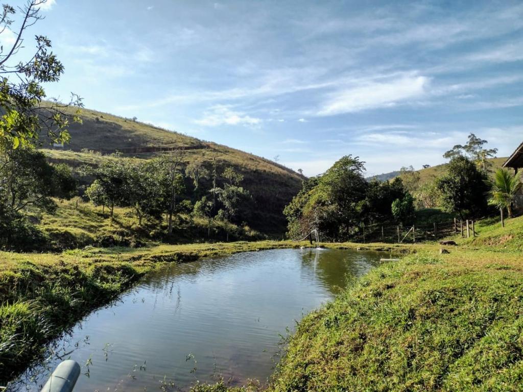 a river in the middle of a grassy field at Rancho Zé Valentim in São José dos Campos