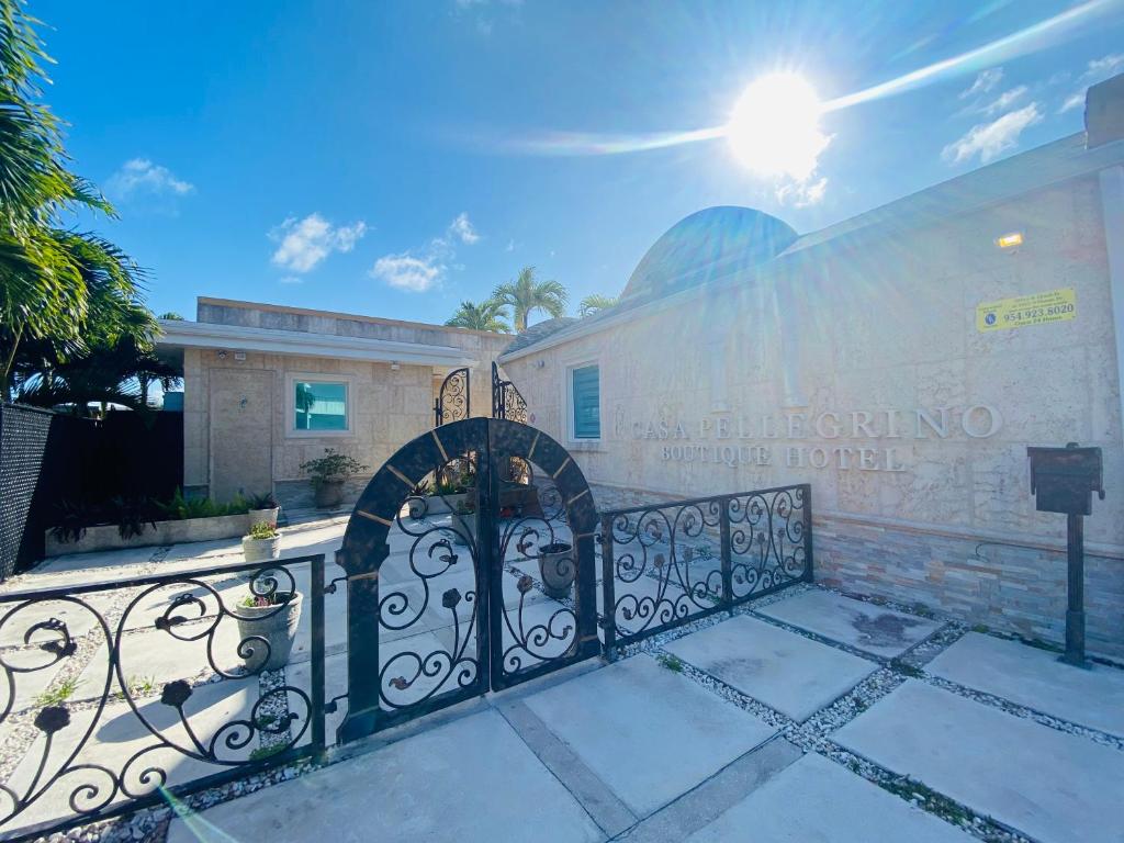 a gate in front of a building with the sun behind it at Casa Pellegrino Boutique Hotel in Hollywood