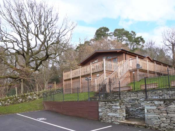 uma casa com uma cerca no topo de uma parede de pedra em High View Lodge em Windermere