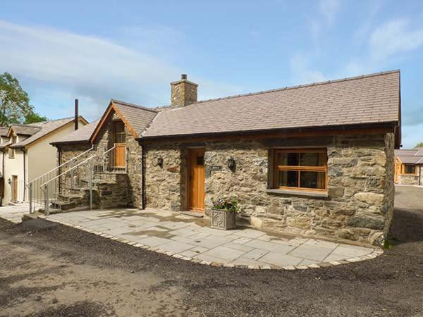 a stone house with a driveway in front of it at Briws in Llangwm