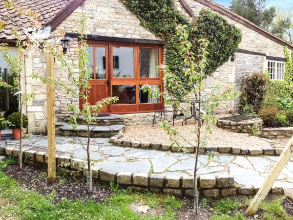 a house with a stone walkway in front of a house at The Aylesbury Cottage in Dyrham