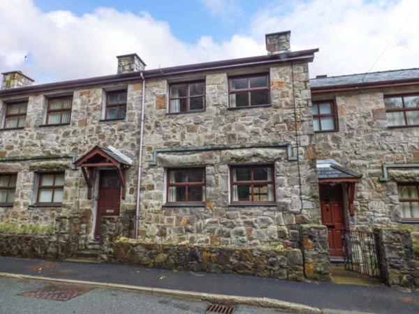 un antiguo edificio de piedra en una calle de la ciudad en 4 Adwy'r Nant, en Beddgelert