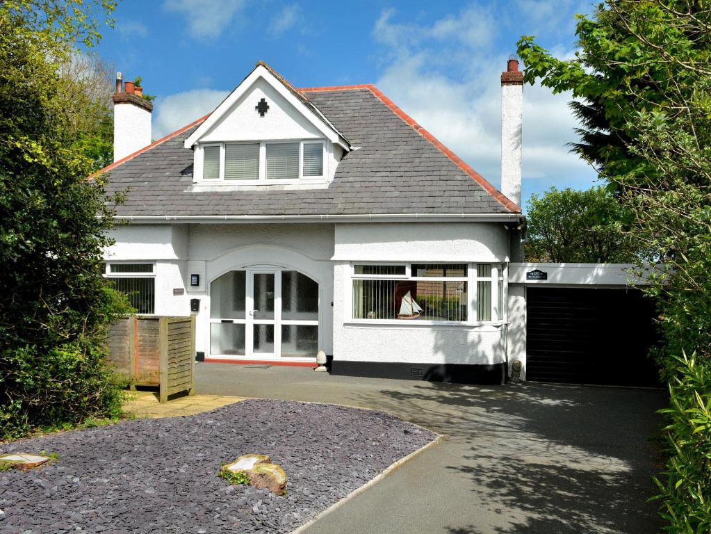 a white house with a gate and a garage at Monarfon in Benllech