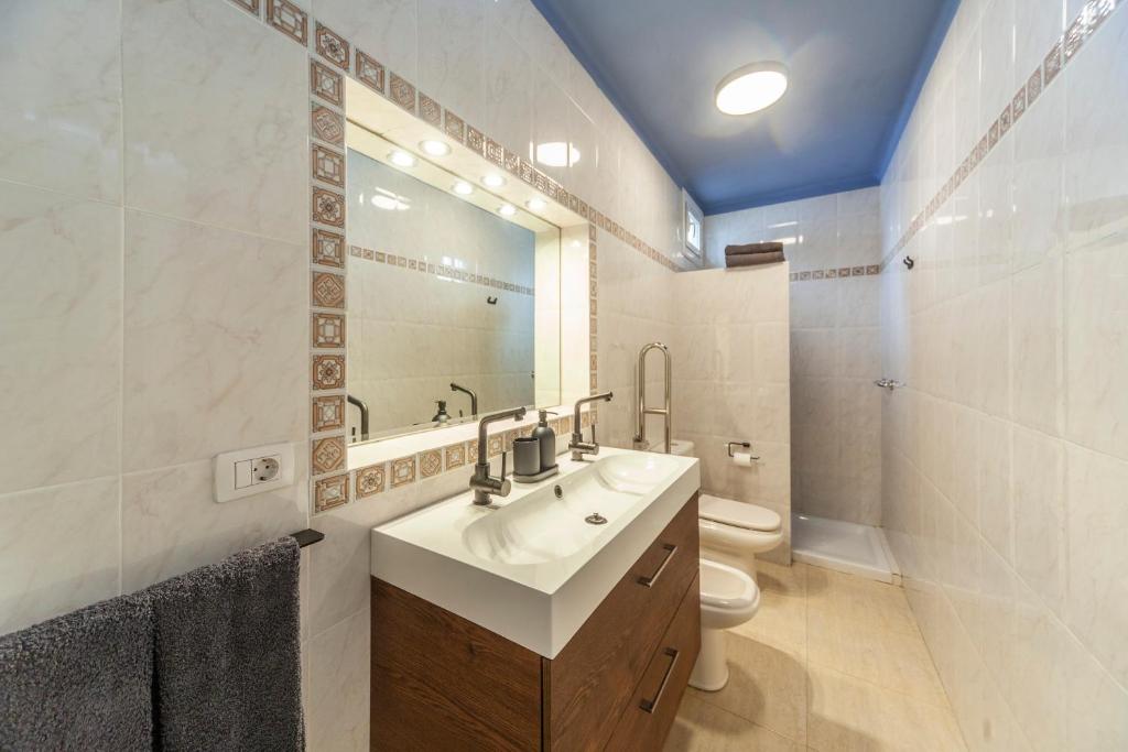 Luxury Suite Sea Front IV في بلايا هوندا: حمام مع حوض ومرحاض ومرآة