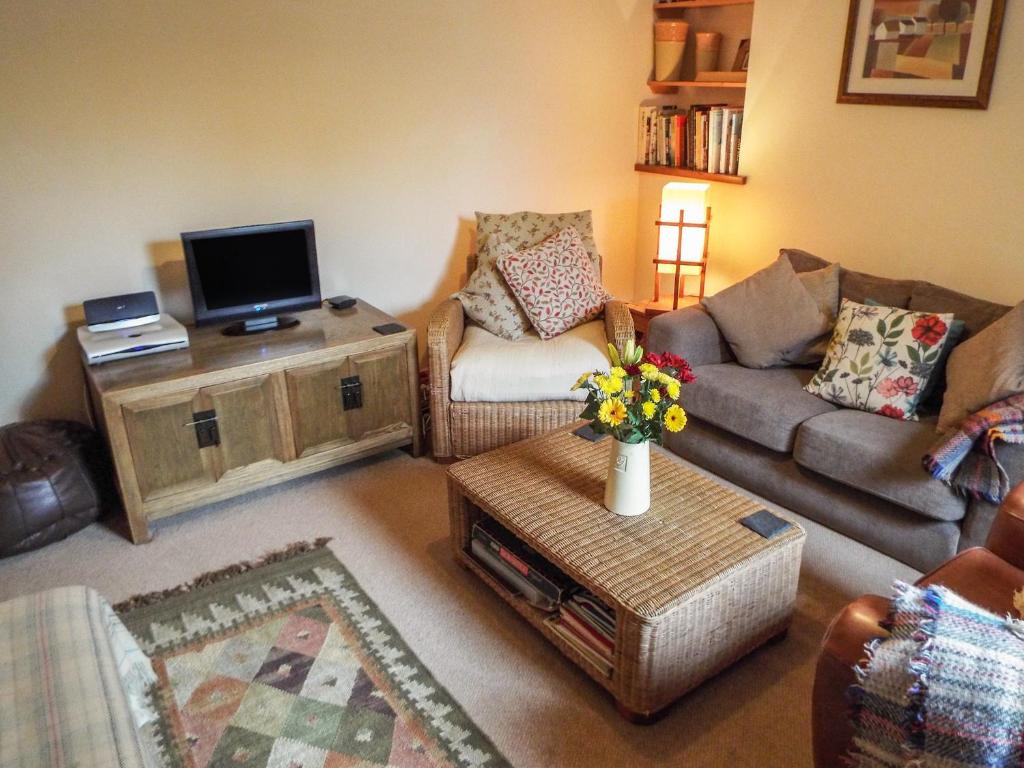 a living room with a couch and a tv at Lothlorien Cottage in Garnant