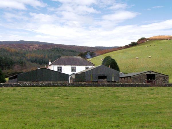 a white house in a field of green grass at Homestone Farm in Drumlemble