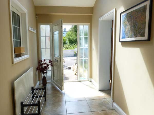 a hallway with a bench and an open door at White Gables in Great Clifton