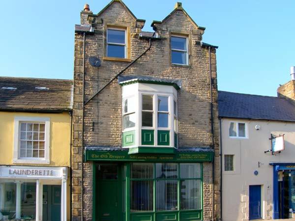 an old brick building with a green door at The Reiver's Retreat in Haltwhistle