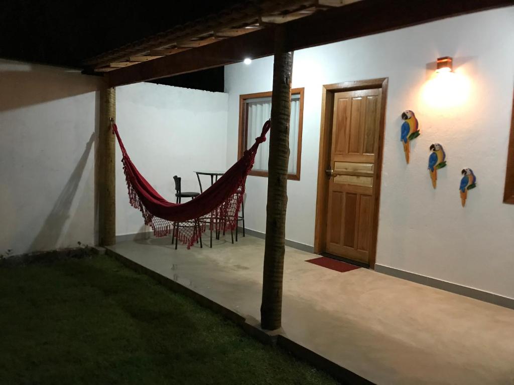 Casa de praia Prado Ba Doces magnólias في برادو: غرفة مع أرجوحة على جانب المنزل