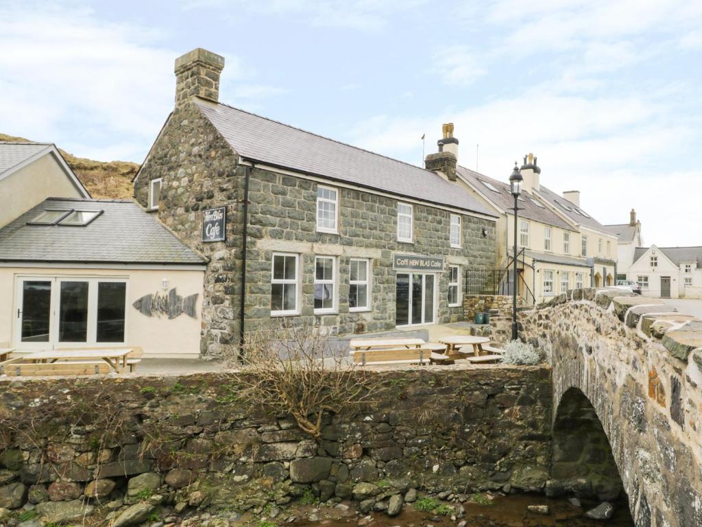 an old stone building with a bridge in front of it at Hen Blas in Aberdaron