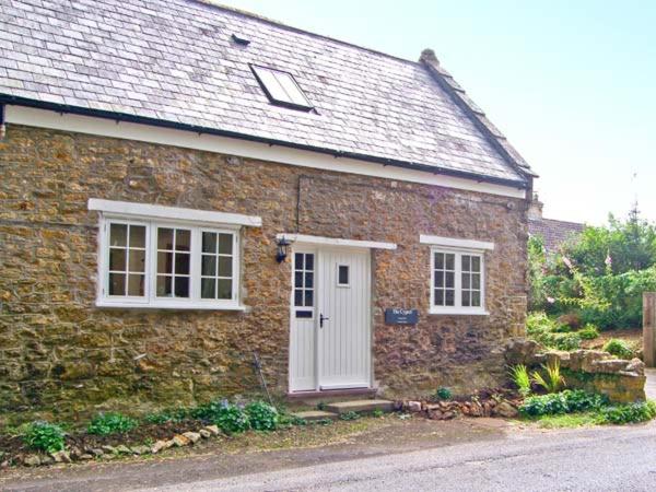 a brick house with a white door and windows at The Cygnet in Haselbury Plucknett