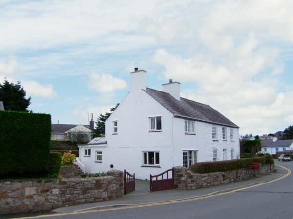 una casa blanca con una valla delante en Glan Y Don Bach en Abersoch