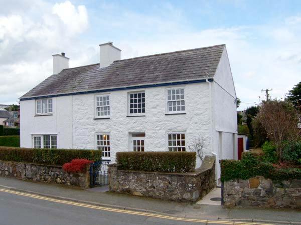 a white house sitting on the side of a street at Glan Y Don in Abersoch