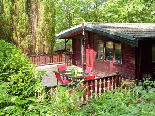 een kleine hut met een tafel en stoelen op een terras bij Top Lodge, 4 Skiptory Howe in Windermere