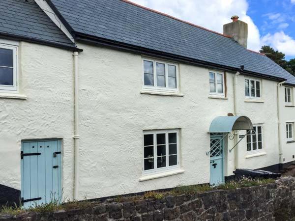 a white house with a blue door and windows at Greenslades in Exford