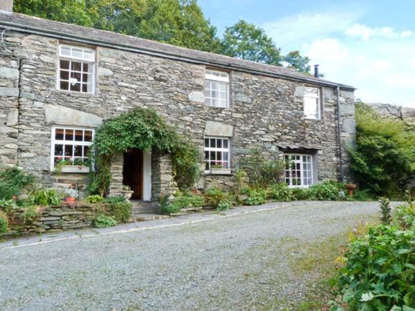 a stone house with a driveway in front of it at High Kiln Bank Cottage in Ulpha