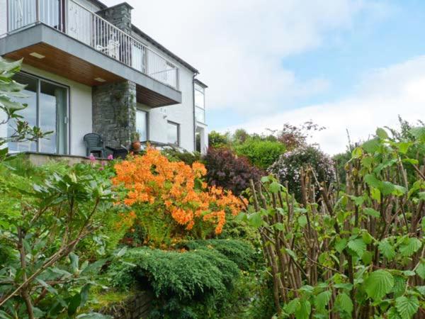 a garden with orange flowers in front of a house at Walker's Retreat in Ambleside