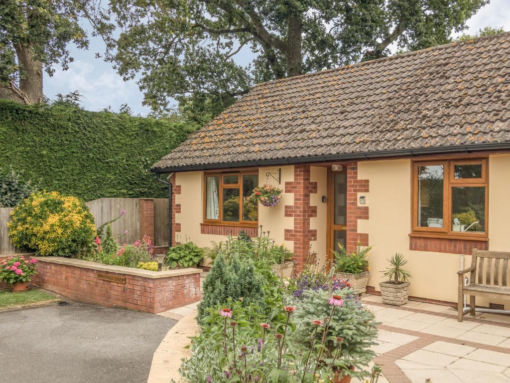 a small house with a bench in a garden at Pipistrelle Lodge in Plymtree