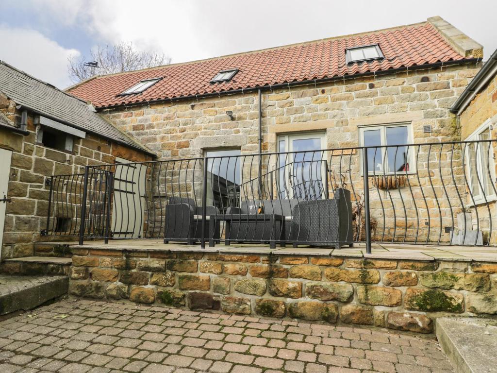 a stone house with a wrought iron fence at Coopers Barn in Egton