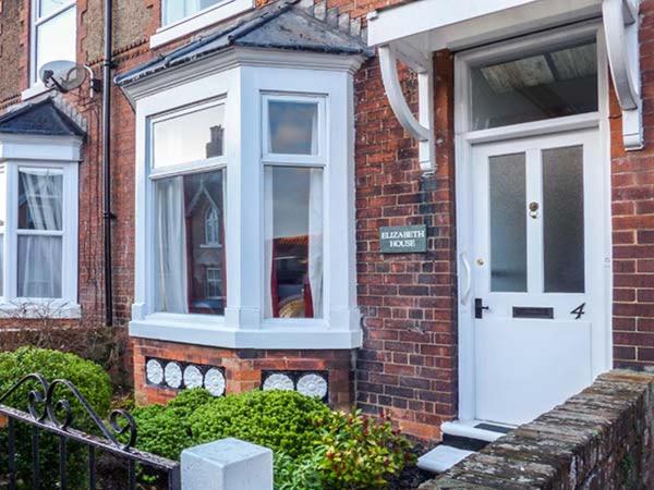 a brick house with a white door and window at Elizabeth House in Hornsea