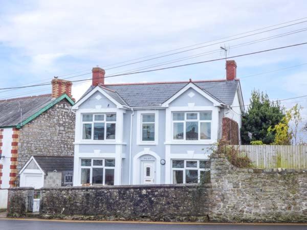 a white house with a stone wall at Pen Hill in Llantwit Major