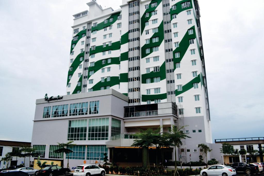 duży budynek z samochodami zaparkowanymi przed nim w obiekcie Amansari Hotel Desaru w mieście Desaru