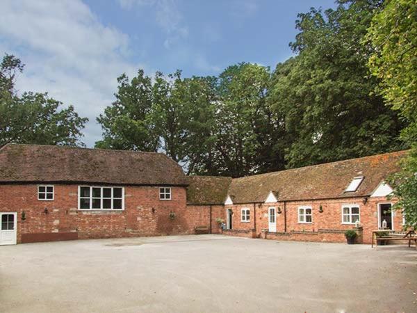 a large red brick building with a large driveway at Finwood Cottage 1 in Rowington