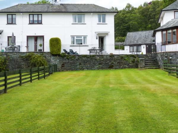 un gran patio frente a una casa blanca en Thompson Cottage, en Troutbeck